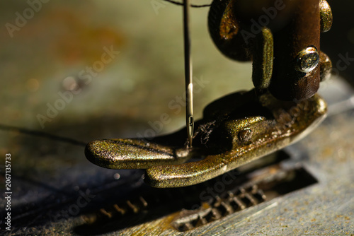 Foto Extreme macro photograph focusing on the needle eye and metal presser foot of an