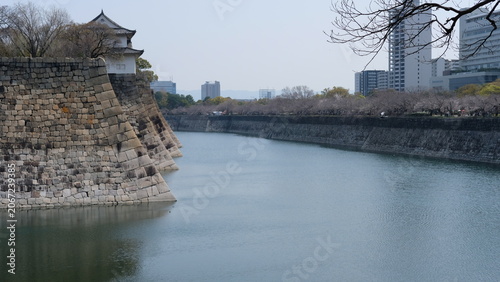 Foto Historic Osaka Castle Moat and Ancient Stone Walls with Modern City Skyline, Jap