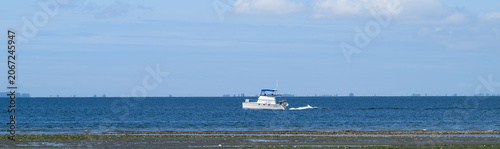 Slika na platnu Boating in Puget Sound on a sunny spring day, white yacht off the coast at low t