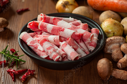 Billede på lærred Raw Beef Brisket Rolls: Fresh Thinly Sliced Chadolbagi in Black Bowl with Cookin