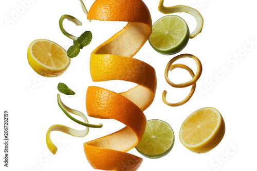 Fresh citrus fruits including lemon and lime slices, orange peels, and green mint leaves floating against a solid black background, vibrant colors