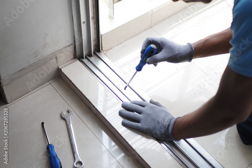 Photos Worker repairs sliding door track in home