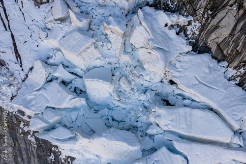 Photos Aerial View of Broken Glacier Ice and Crevasses Against Rocky Cliffs in British
