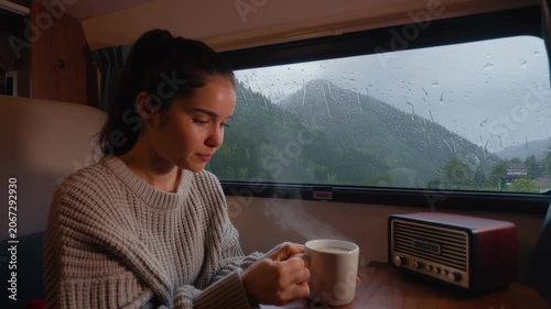 Woman Drinking Coffee inside Camper Van during a Rainy Day in Nature