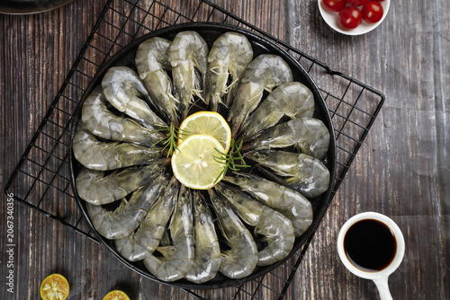 Fresh Frozen Prawns with Lemon and Herbs on Dark Plate