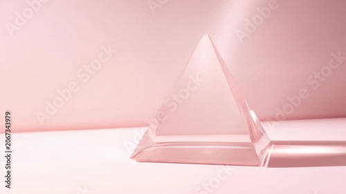 Transparent pyramid on pink surface with soft lighting and shadows