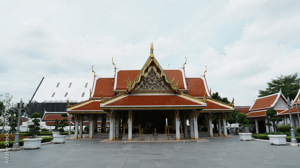 Obraz premium Wide Panoramic Front View Traditional Thai Temple Main Hall Vast Empty Stone Plaza