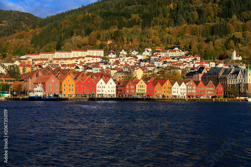 Panorama of Bergen Port with colorful wooden hanseatic buildings of World Heritage Site Bryggen, boat and mountain in autumn in Norway