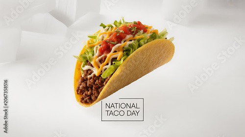 A close-up of a taco filled with ground meat, lettuce, cheese, and salsa, presented against a clean white background with text indicating National Taco Day.