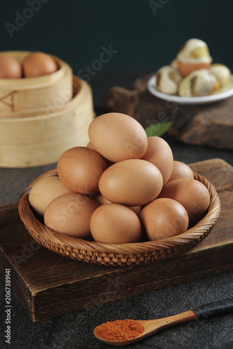 Fresh Brown Chicken Eggs in Wicker Basket on Rustic Wood Kitchen Counter