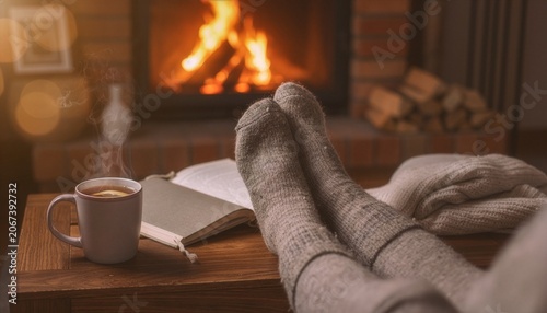 Woolen socked feet resting by fireplace with tea and open book