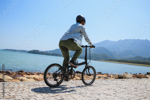 Riding folding bike on seaside road