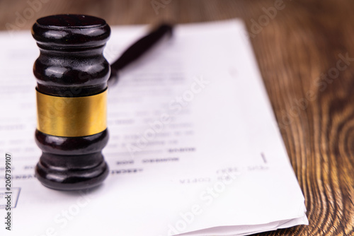 Foto Close look of a classic mahogany judge gavel sitting on official legal case docu