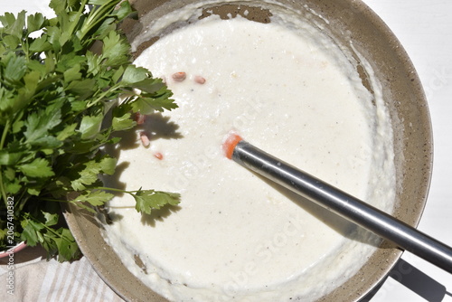 Bild auf Leinwand Homemade Béchamel Sauce for Lasagna in Skillet with Fresh Parsley, Close Up
