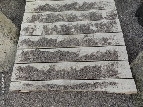 Weathered Wooden Pillars Covered with Sand on the Beach.