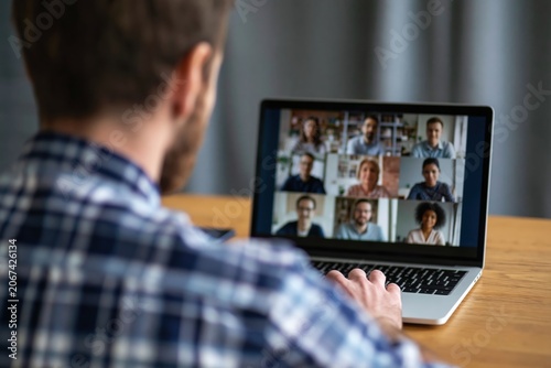 Man working on laptop during a virtual video conference meeting for remote work