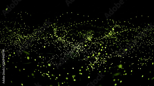 Fireflies glow with a soft yellow light in the darkness to create a magical and enchanting night scene.