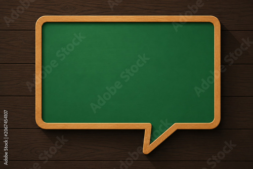 Speech Bubble Shaped Green Chalkboard with Wood Frame on Horizontal Wooden Plank Background. Minimalist Chat Icon Blackboard for Quotes, Announcements, and Copy Space.