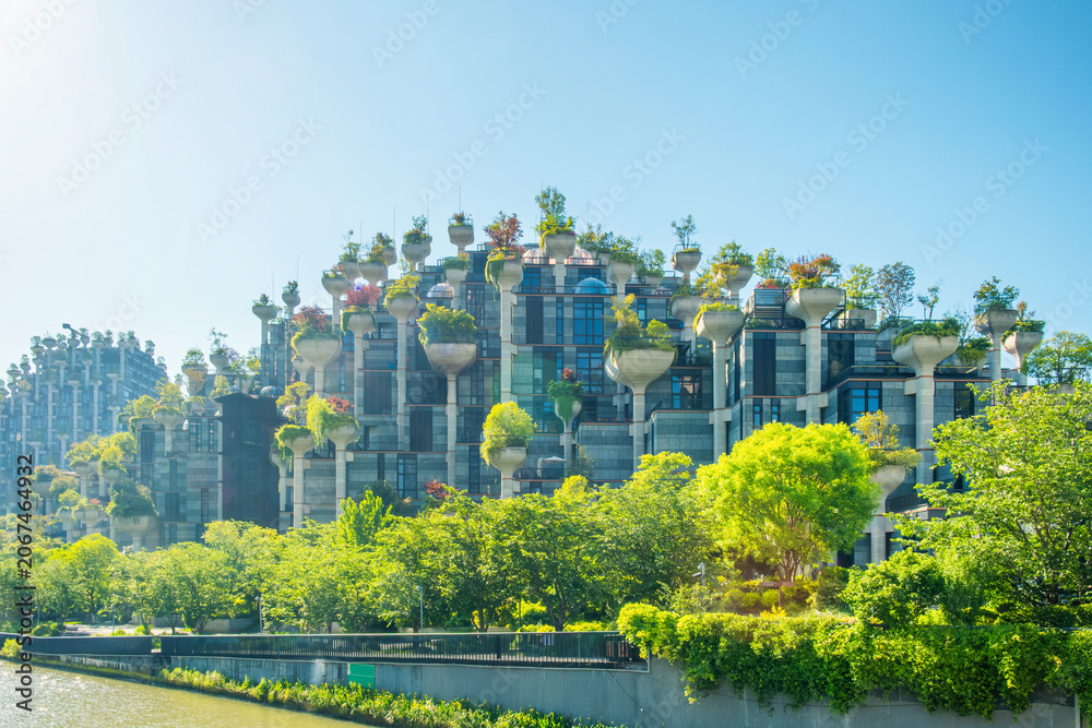 Obraz premium Innovative design green building with elevated rooftop gardens, integrated vegetation and sustainable architecture in Shanghai city, China. Modern urban development, green infrastructure