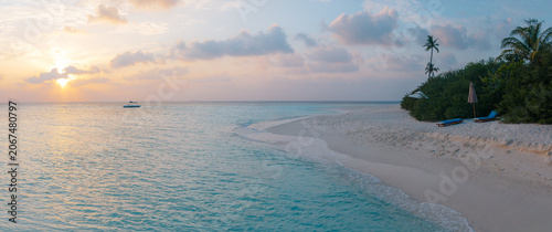 Vacation summer holidays leisure background - sunny tropical Caribbean paradise resort beach with white sand, lounger, palms on Maldive