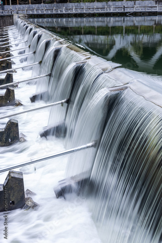 Bild auf Leinwand Water Flow Over Dyke - Landscape with Cascading Water