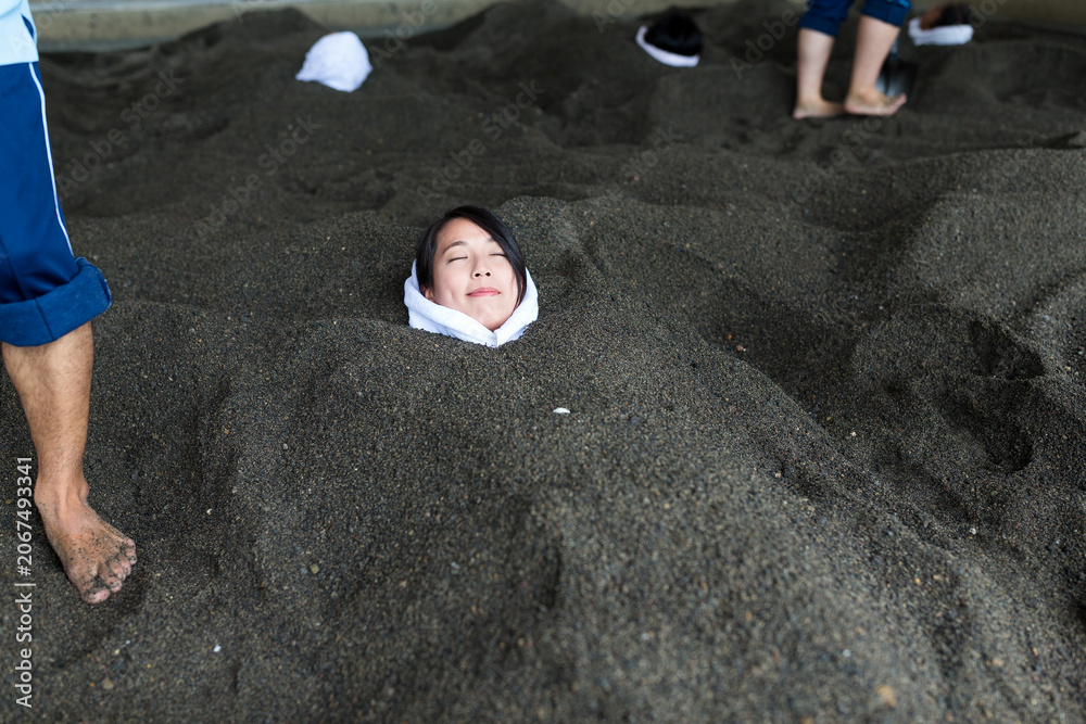 Fototapeta premium Woman relaxing in hot sand bath&nbsp;