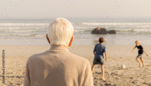 rear view of elderly man looking out at ocean waves, grotto beach, hermanus, South Africa