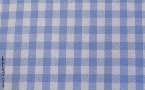 Texture of classic light blue plaid cotton cloth background. Close up of light blue and white gingham fabric. 