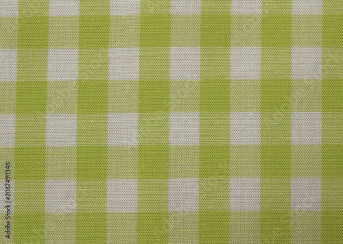 Close up of lime green and white plaid fabric. Texture of classic green gingham cotton cloth background. 