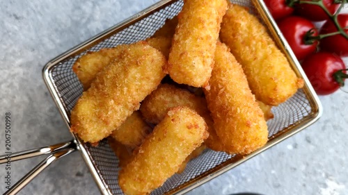 Mozzarella cheese sticks, breaded and fried with salt, spices, and tomato sauce, for takeaway. Cheese sticks as a food background for your design