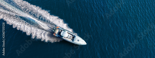 Aerial drone ultra wide top down photo with copy space of luxury rigid inflatable speed boat cruising in high speed in Aegean deep blue sea, Greece	