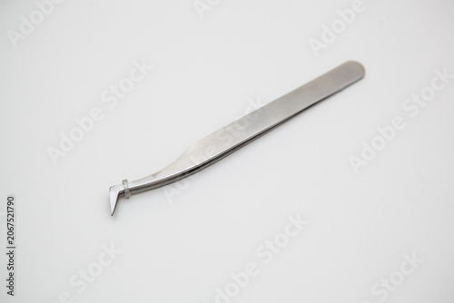 tools for eyelash extension and eyebrow design. cosmetic tweezers in silver color on a white background