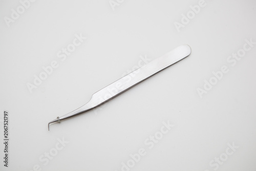 tools for eyelash extension and eyebrow design. cosmetic tweezers in silver color on a white background
