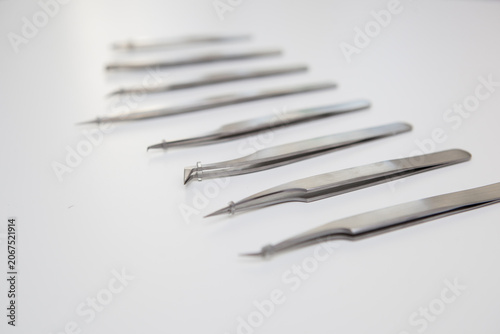tools for eyelash extension and eyebrow design. cosmetic tweezers in silver color on a white background
