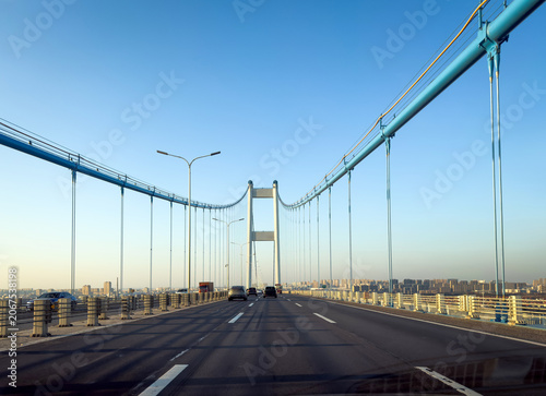 Stunning Visual of a Modern Bridge Over a Highway Bathed in Warm Sunset Light