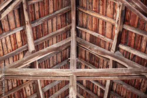An intricate network of wooden beams and planks used to support a roof