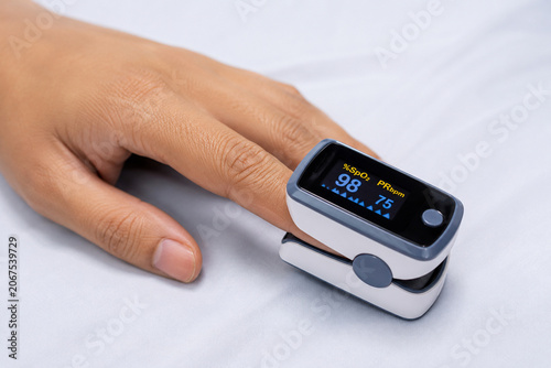 Patient Finger with Pulse Oximeter Measuring Oxygen Saturation and Heart Rate, Healthcare Monitoring Concept