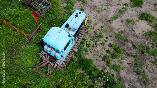 Fotografija Old rusty blue tracked tractor standing in a rural field on a sunny summer day