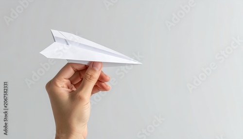 A clean minimal conceptual photo of a paper airplane held in a hand, symbolizing creativity, innovation, and startup ideas