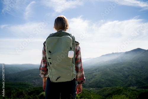 Cuadro en lienzo A hiker woman admires the mountain landscape during a hiking adventure in sunny weather in a beautiful valley