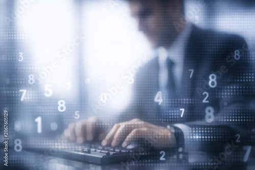 This is a stock photo of a businessman sitting at a desk and typing on his laptop computer. There's an overlay of numbers that suggest data analysis or financial work being done.