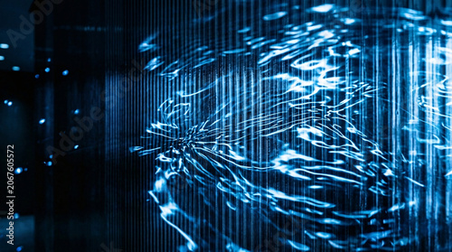 Abstract blue light reflection on a corrugated metal texture creating a futuristic digital data ripple effect.