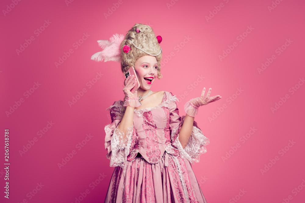 Fototapeta premium Photo of renaissance duchess historical princess queen speaking phone empty space isolated on pink color background