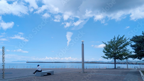 Tableau sur toile 海辺のベンチでお昼休憩するサラリーマン
