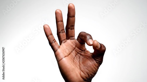 Hand making ok sign against white background.
