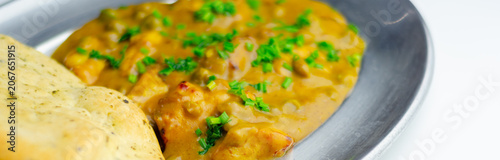Φωτογραφία Warm curry with fresh herbs on a metallic plate