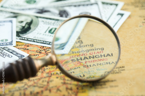 Photography Magnifying Glass Over Shanghai Map with US Dollar Banknotes