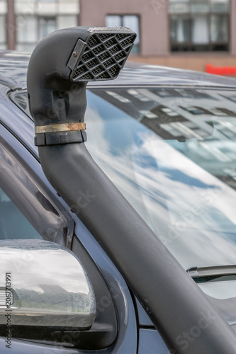 A fragment of an air intake pipe on an SUV on a summer day