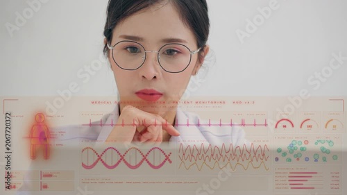 Serious female Asian doctor looking through a futuristic HUD medical interface displaying patient vital signs, DNA, and lab results, representing virtual healthcare and diagnostic technology