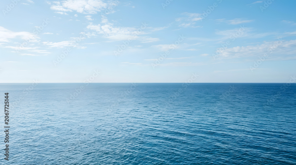 Fototapeta premium Calm blue ocean horizon under a clear sky with light clouds